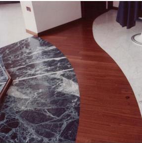 Doppia pavimentazione: marrone emperador e bianco di Carrara separati da una fascia in parquet